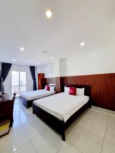 a bedroom with two beds and a desk in it at Minh Khue Hotel in Vĩnh Long