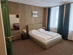 1 dormitorio con cama y espejo grande en Central Hotel with Free parking, en Riga
