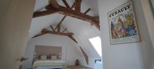 1 dormitorio con vigas de madera en el techo en La Demeure de l'Aubance en Saint-Mélaine-sur-Aubance