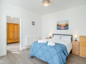 a bedroom with a large bed with a blue blanket at Two - Uk43700 in Saint Annes on the Sea