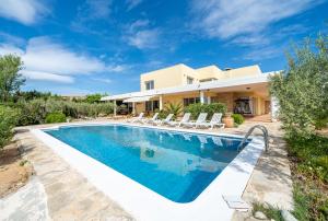 a villa with a swimming pool in front of a house at Vila Roser in L'Ametlla de Mar