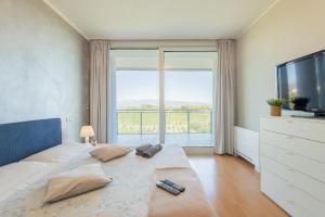 a bedroom with a large bed and a large window at Glass House in Cuneo