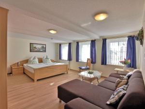 a living room with a bed and a couch at Clausen - Ferienwohnung mit 4 Schlafzimmern, 2 Bädern, Aufenthaltsraum mit Kamin und Garten in Janneby