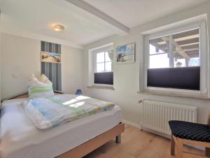 a bedroom with a bed and two windows at Ferienwohnung Clausen in Janneby