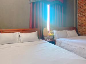two beds sitting next to each other in a bedroom at Sunshine villa thuan an in Hue