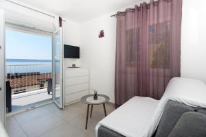 Apartments Bandić - 30 meters to the beach في تروغير: غرفة نوم مع سرير وإطلالة على المحيط
