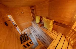 an overhead view of a wooden sauna with yellow pillows at 2 Bedroom Roof Terrace SPA with Sauna plus Jakuzzi and Outdoor Cinema in London