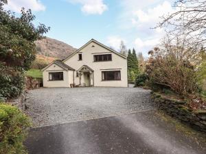 a white house on a gravel driveway at Rawfell in Ambleside