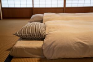 three beds lined up in a room with a pillow at Yochi-in in Koyasan