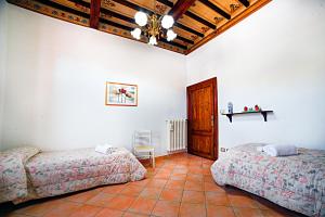 a bedroom with two beds and a wooden ceiling at La casa di Giulina in Siena