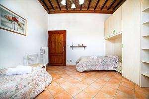 a bedroom with two beds and a table and a shelf at La casa di Giulina in Siena