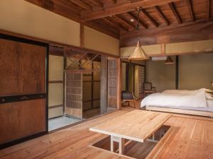 a bedroom with a bed and a wooden floor at NIPPONIA Izumo Taisha Shrine Town in Izumo
