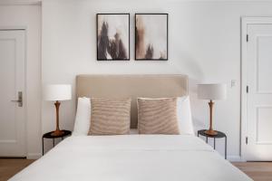 a bedroom with a large white bed with two lamps at Midtown East 1br w gym wd nr Grand Central NYC-1108 in New York