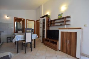 a living room with a dining room table and a television at Holiday Home Pere in Malinska