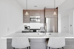 a kitchen with a white counter and two chairs at Downtown BK 1BR w WD Deck nr TJ NYC-879 in Brooklyn