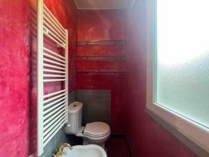 łazienka z toaletą i czerwoną ścianą w obiekcie Casa Ida w mieście Lerici