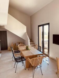 ein Esszimmer mit einem Holztisch und Stühlen in der Unterkunft RESIDENCE SAMBRO - Jacuzzi et piscine chauffée vue mer - 4 étoiles in Les Issambres