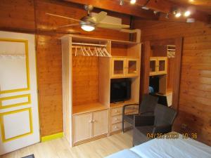 a bedroom with wooden walls and a bed and a tv at Locatlantique in Aytré