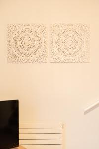 dos pinturas en una pared blanca con TV en Harmonious 2Bed Apartment-Suits Contractors en Leeds