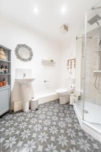 a bathroom with a tub and a sink and a toilet at Harmonious 2Bed Apartment-Suits Contractors in Leeds