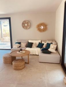 un soggiorno con divano e tavolo di RESIDENCE SAMBRO - Jacuzzi et piscine chauffée vue mer - 4 étoiles a Les Issambres