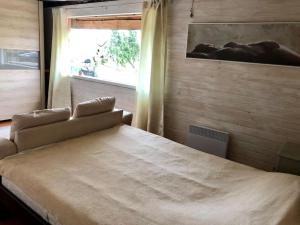 a bedroom with a large bed with a window at Privaatne mereäärne maamaja tõeliseks puhkuseks! in Emmaste