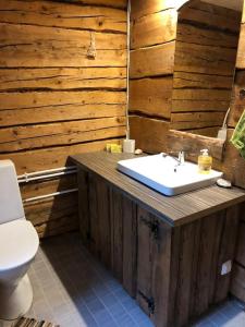 a wooden bathroom with a sink and a toilet at Privaatne mereäärne maamaja tõeliseks puhkuseks! in Emmaste