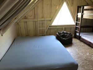 a bed in a room with a ladder and a window at Privaatne mereäärne maamaja tõeliseks puhkuseks! in Emmaste +27 photos