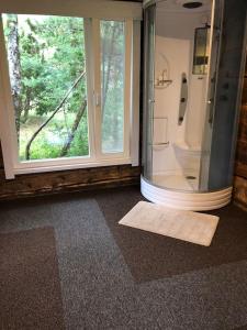 a bathroom with a shower with a window and a mat at Privaatne mereäärne maamaja tõeliseks puhkuseks! in Emmaste