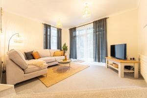 Harmonious 2Bed Apartment-Suits Contractors في ليدز: غرفة معيشة مع أريكة وتلفزيون