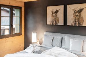 a bedroom with a bed with two deer heads on the wall at Swiss Hotel Apartments - Gstaad in Gstaad