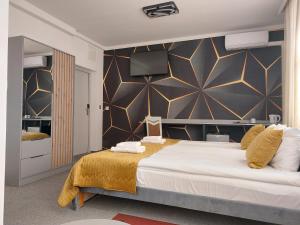 a bedroom with a bed and a wall with a television at Perla in Augustów