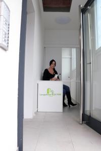 Lux Apartmani Novi Park في فردنيك: امرأة تجلس في كونتر في غرفة