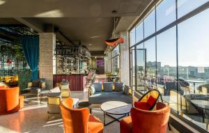 a restaurant with chairs and tables and windows at Dusit Princess Hotel Residences Nairobi in Nairobi