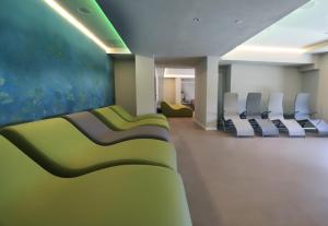 a waiting room with white chairs in a hospital at Hotel Fonte Boiola in Sirmione