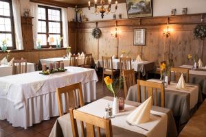 a restaurant with tables and chairs with white tablecloths at Hotel Dietmayr in Neumarkt in der Oberpfalz