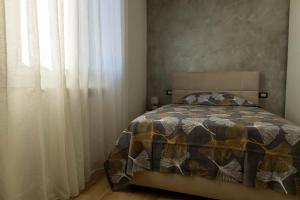 1 dormitorio con 1 cama y una ventana con cortinas en Maison 140, en Lonato