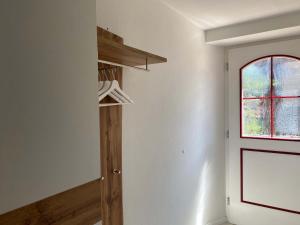 Zimmer mit weißen Wänden, einem Fenster und einem Regal in der Unterkunft Bei Dörflingers in Klettgau
