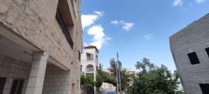an alley between two buildings with the sky in the background at Reema's House in Beit Sahour