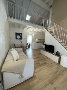 sala de estar con sofá blanco y escalera en Maison 140, en Lonato