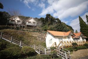 a group of houses on a hill with trees at Tennenonsen Amuri in Amakusa