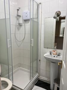 a bathroom with a shower and a sink at Mayfair Guest House in Cardiff