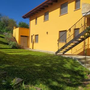 a yellow house with a staircase next to a yard at Agriturismo Tenuta Umberto I in Ripacorbaria