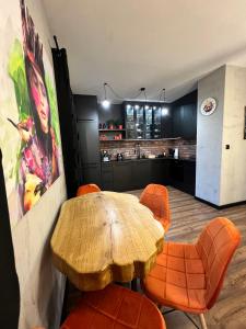a dining room with a wooden table and orange chairs at Silesia Apartments B129 in Ustroń