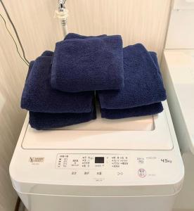una pila de toallas sobre una lavadora en ゲストハウスＥｎ 
