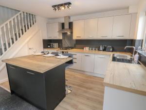 a kitchen with white cabinets and a wooden counter top at Bowshaw in Holmfirth