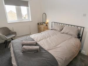 a bedroom with a large bed with two towels on it at Bowshaw in Holmfirth