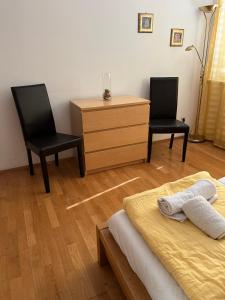 Stelius Wien في فيينا: غرفة نوم بها كرسيين وسرير وخزانة