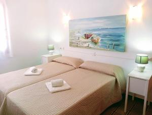 a bedroom with a bed and a painting on the wall at Apartamentos MHM in Cala Ratjada