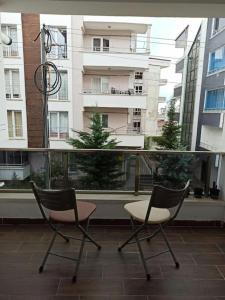 2 sillas sentadas en un balcón con un edificio en Home Home en Çavuş
